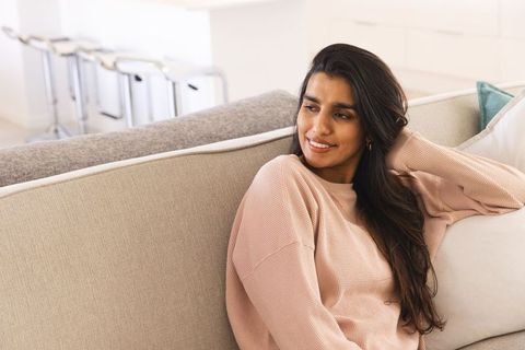 Relaxed Indian Woman Enjoying Leisure Time in Cozy Modern Living Room
