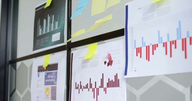 Business charts and graphs on office wall, showing data analysis for presentations and reports. Useful for depicting workplace environments, business meetings, financial planning, and project management. Ideal for marketing materials, corporate websites, and educational content about data analysis.