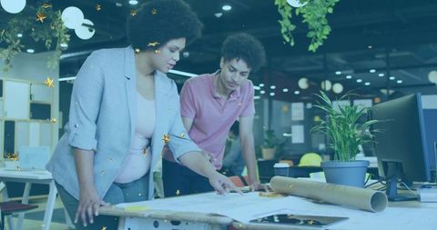 Creative Professionals Reviewing Blueprints in Stylish Urban Office