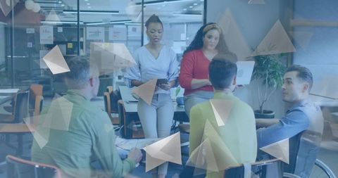 Two Women Leading Collaborative Business Meeting in Modern Office Using Tablet and Charts