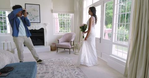 Photographer Capturing Bride Holding Bouquet in Elegant Living Room