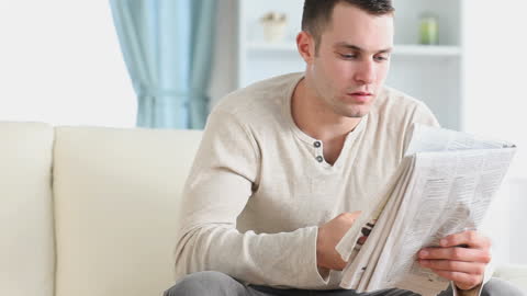 Man Engaged in Reading Morning Newspaper at Home