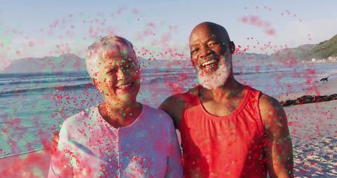 Elderly couple celebrating beachside embraced by vivid colors and joy