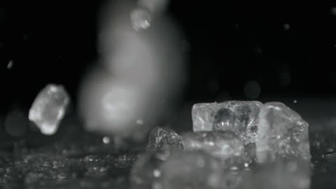 Ice Cubes Dropping in Slow Motion Against Dark Background