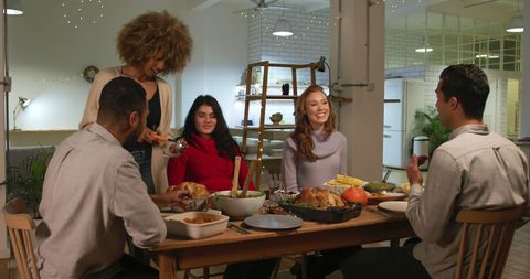 Diverse Group of Friends Enjoying Laughter and Dinner Together