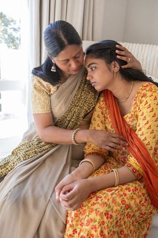 Mother comforts daughter in traditional indian attire