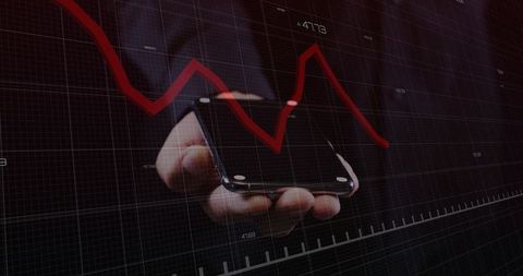 Hand holding smartphone with declining red stock chart overlay for finance analytics