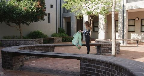 Woman Organizing Items in Serene Urban Courtyard Landscape