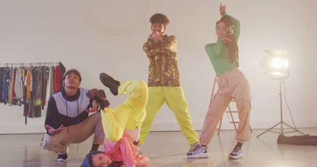 Group of young multicultural individuals involved in dynamic street dance poses in a bright studio. Various vibrant outfits and confident expressions reflect energy and vitality, making the visual perfect for promos related to dance, youth culture, urban fashion, or lifestyle campaigns.