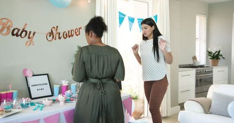 Multiracial friends setting up decorations for baby shower party