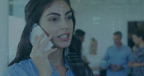 Young woman holding smartphone and talking in modern office with digital code overlay