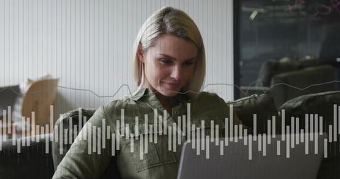 Woman concentrating on laptop in contemporary coworking lounge