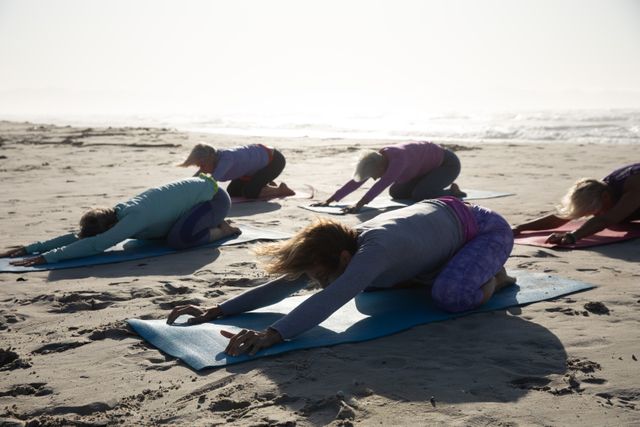 Group of woman practicing yoga on the beach - Download Free Stock Photos Pikwizard.com