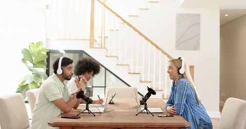 Diverse colleagues recording podcast in modern home interior