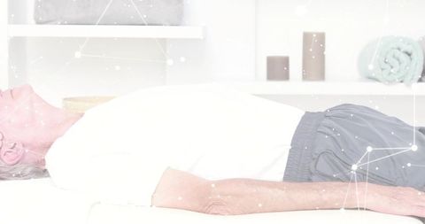 Senior man resting on treatment table in bright clinic for rehabilitation therapy