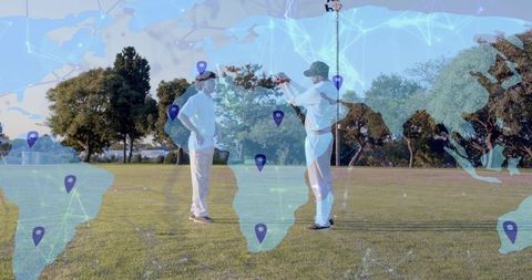 Cricket players gesturing on sunlit field with global map and geolocation data overlay