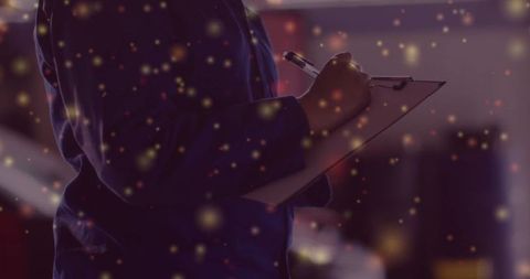 Professional Female Writing on Clipboard in Dim Warehouse