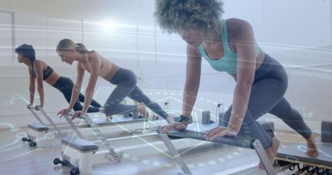 Women Performing Reformer Plank in Pilates Studio for Strength and Flexibility