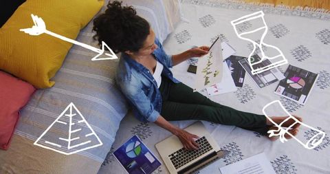 Woman Analyzing Data Sheets with Laptop in Cozy Home Office Space