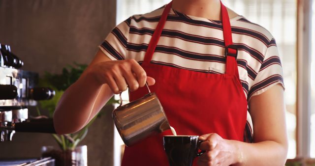 Barista in Red Apron Pouring Milk into Coffee Mug in Cafe - Download Free Stock Images Pikwizard.com