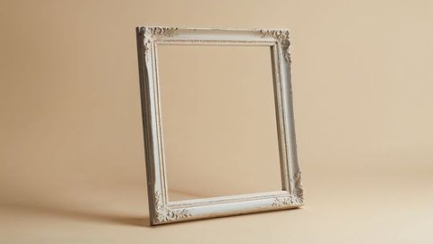 Empty ornate picture frame against beige backdrop for elegant decor