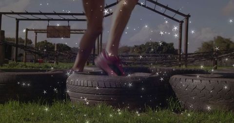 Woman navigating tire obstacle course in stylish pink running shoes