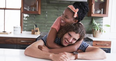 Laughing Couple Embracing in Warm Kitchen Setting - Download Free Stock Images Pikwizard.com