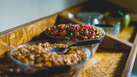 Colorful Breakfast Cereal Bowls with Spoons on Rustic Wooden Serving Counter Close-up