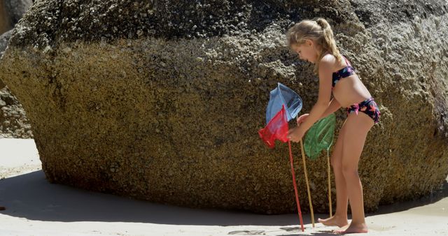 Young Girl Playing on Beach with Fishing Nets by Large Rock - Download Free Stock Images Pikwizard.com