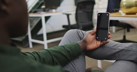 Businessman in Office Relaxed Using Smartphone with Copy Space on Screen