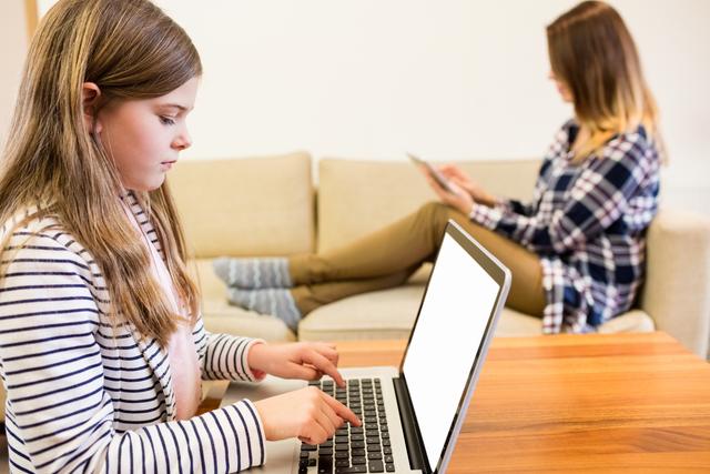 Girl using laptop in living room at home