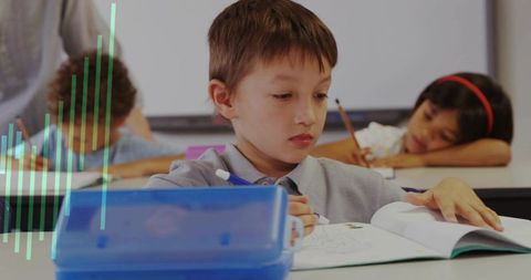 Focused School Boy Writing in Classroom with Blue Supplies