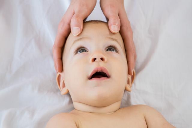 Mother Touching Baby Boy's Head with Care - Download Free Stock Photos Pikwizard.com
