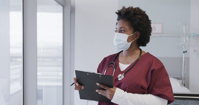 Healthcare Professional Wearing Mask Holding Clipboard in Hospital - Download Free Stock Images Pikwizard.com