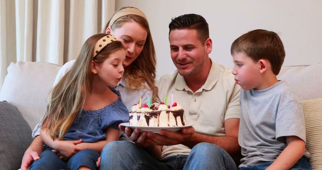 Family Celebrating Birthday with Cake at Home on Sofa - Download Free Stock Images Pikwizard.com