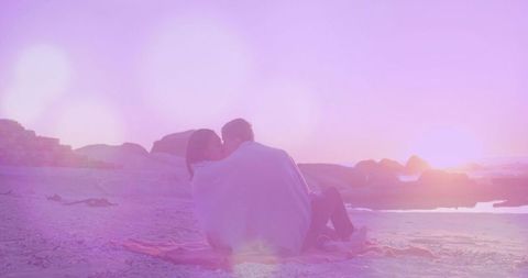Couple Enjoying Romantic Coastal Sunset Wrapped in Blanket