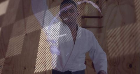 Martial artist training under dramatic diagonal light with projected pattern