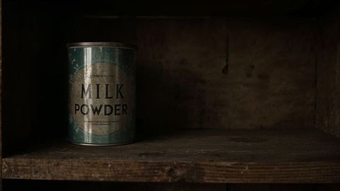 Vintage milk powder can on rustic wooden shelf