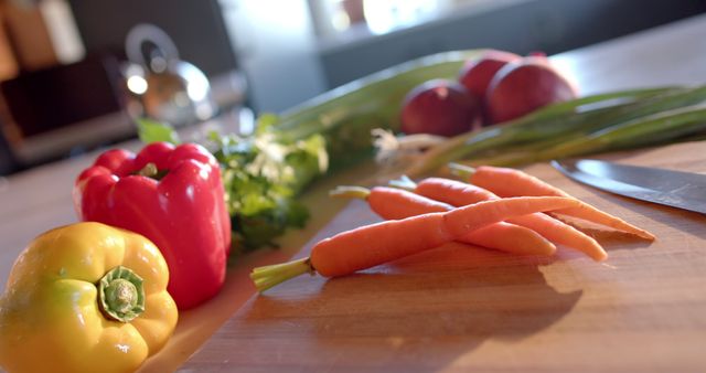 Close-up image of fresh vegetables including bell peppers and carrots on a kitchen counter. Excellent for content related to healthy eating, cooking tutorials, recipe blogs, and promoting fresh, organic foods. It can also be used in kitchen and lifestyle magazines.