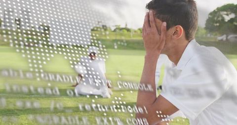 Young athlete covering face while sitting on grass with map overlay double exposure