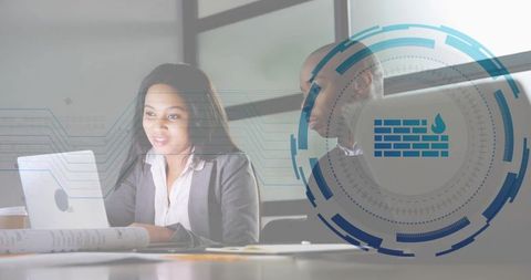 Business team working on laptop with cybersecurity overlay and blueprints