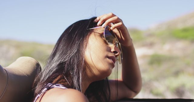 African american woman wearing sunglasses sitting in the convertible car. road trip travel and adventure concept