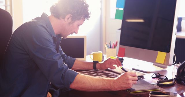 Focused Designer Working at Desk in Modern Office - Download Free Stock Images Pikwizard.com