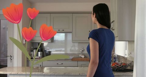 Woman standing in kitchen with creative digital flower overlay