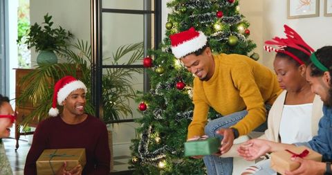 Diverse friends celebrating christmas exchanging gifts with joy