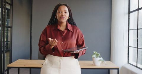 Confident Businesswoman Presenting Ideas with Tablet in Modern Office
