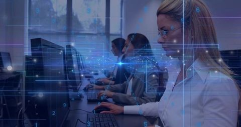 Typing blonde professional at open-plan office workstation with digital data overlay