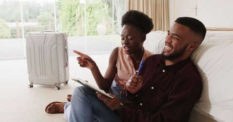 Young couple exploring travel plans at home with technology