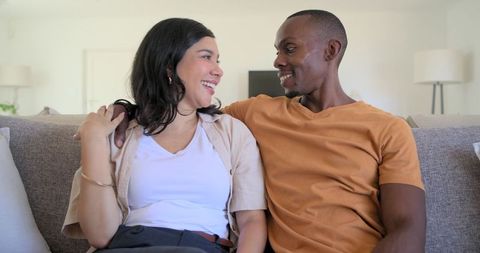 Smiling couple relaxing on sofa in cozy modern living room conveying warm togetherness