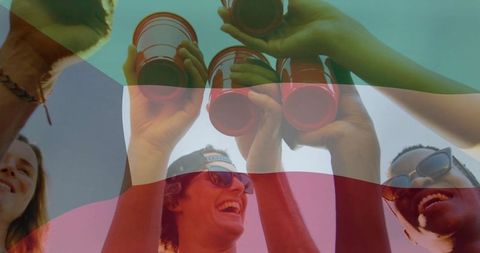 Diverse group of friends toasting red cups under sunlight